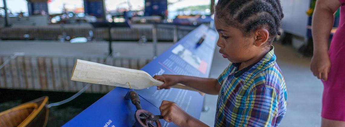 Child reading info on boats